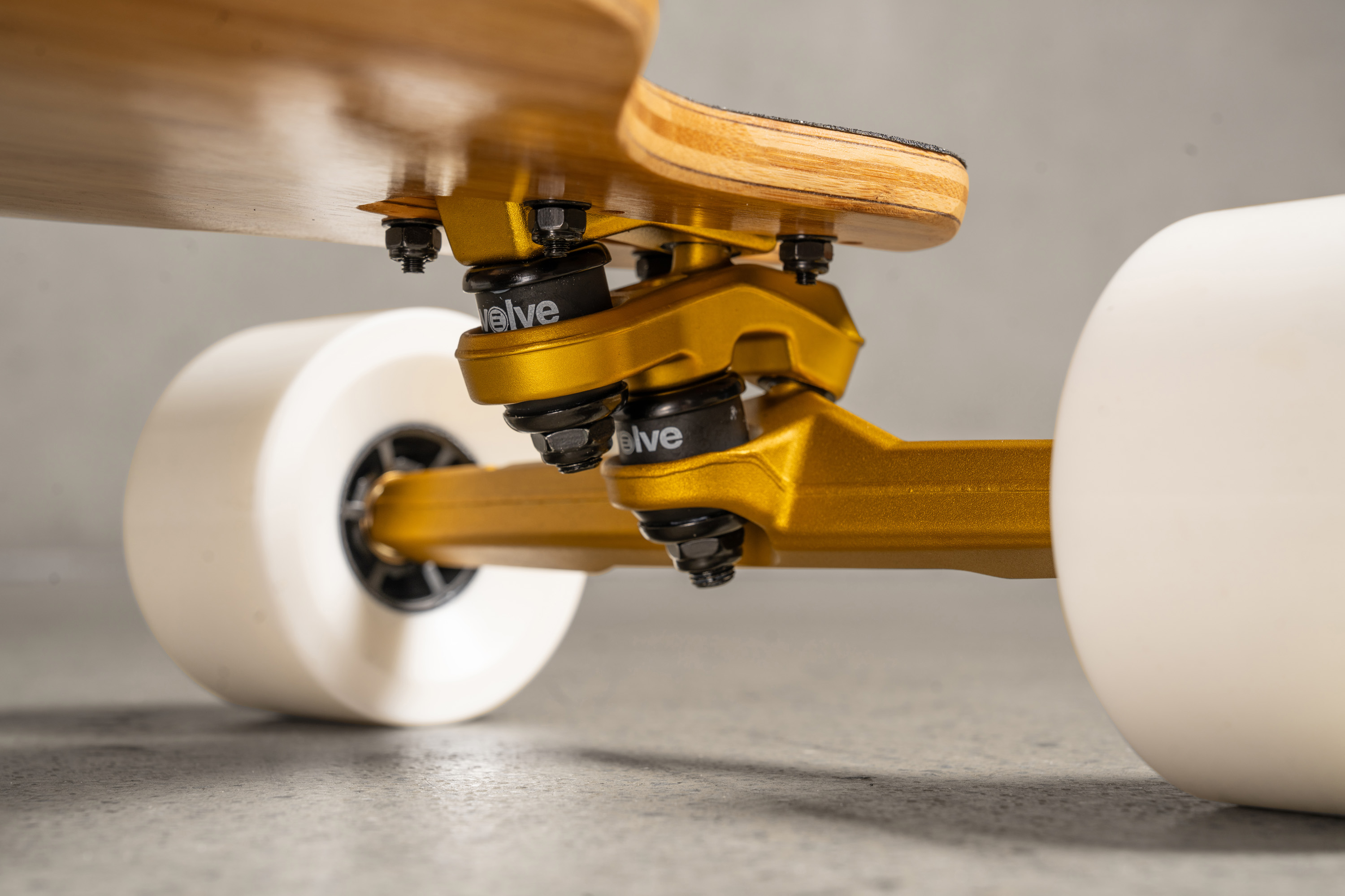 Trucks SuperCarve 2.0 Gold du Evolve Fusion, combinant maniabilité en carving et stabilité à haute vitesse